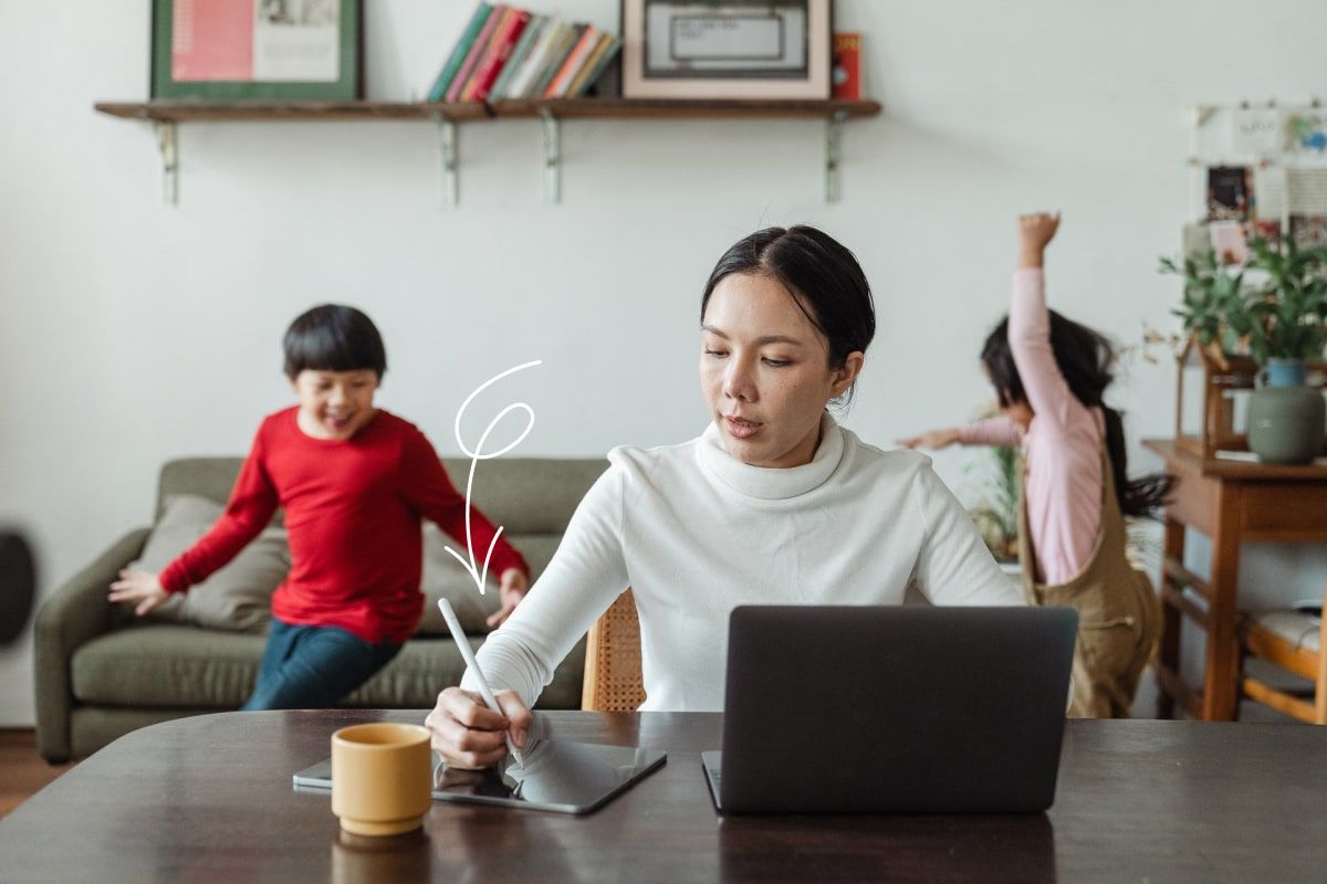 Woman working with two kids in background