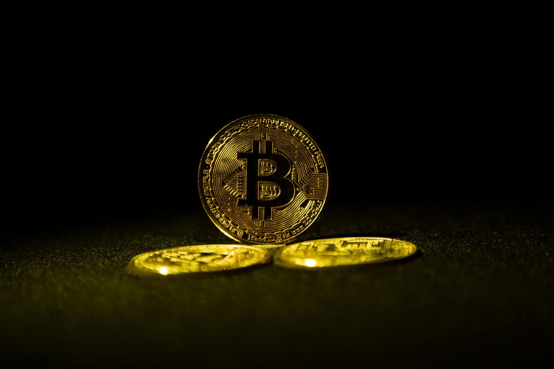 Physical gold coins next to digital blockchain network visualization