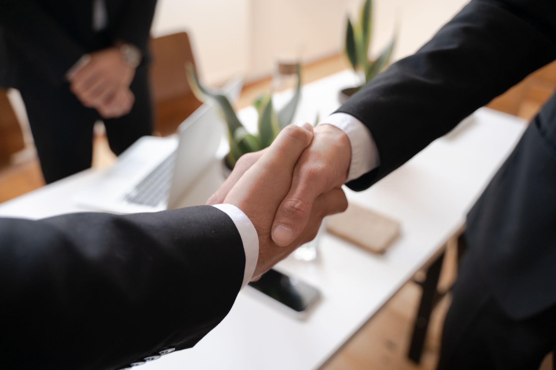 Business professionals shaking hands in modern financial office setting