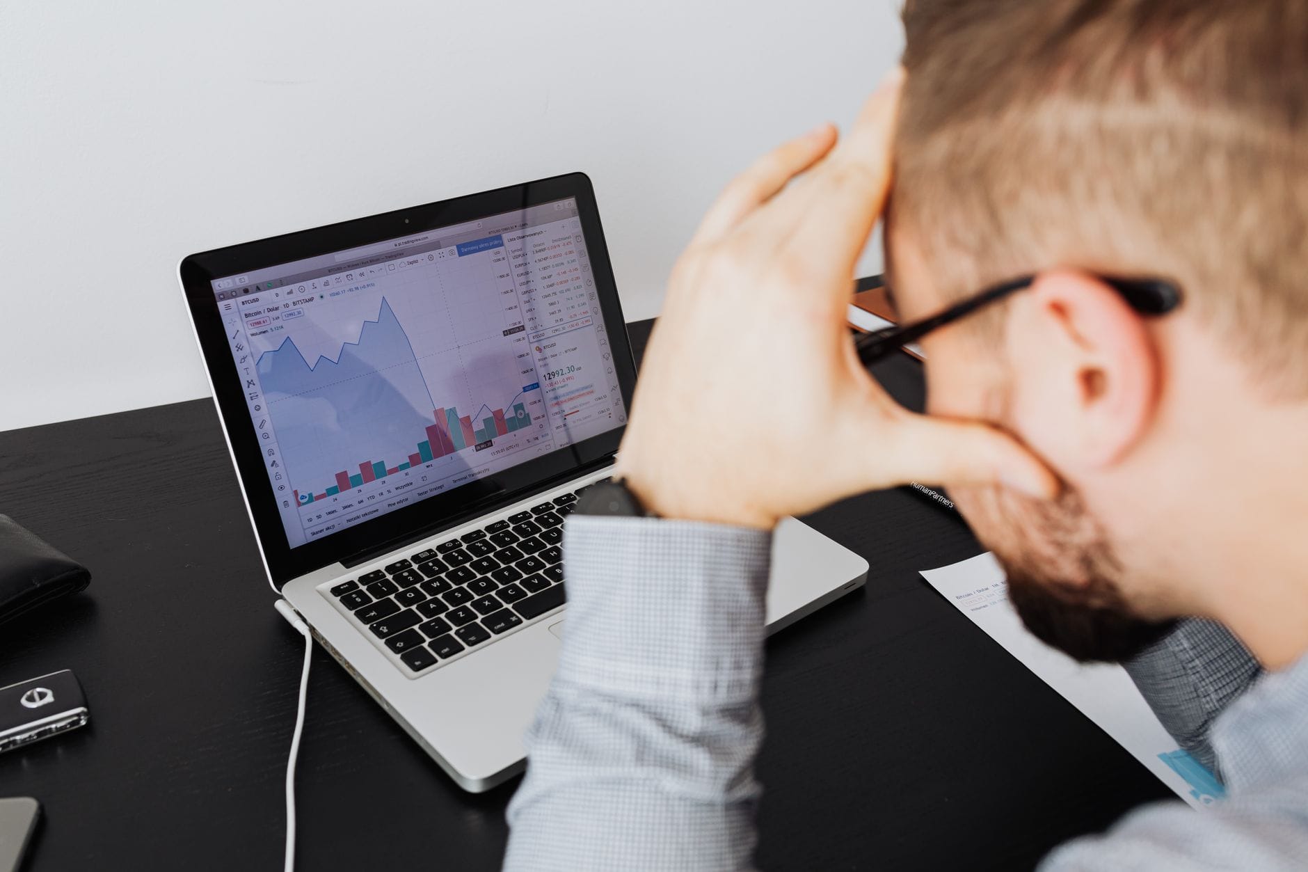 Crypto trader reviewing portfolio during market drawdown on laptop screen