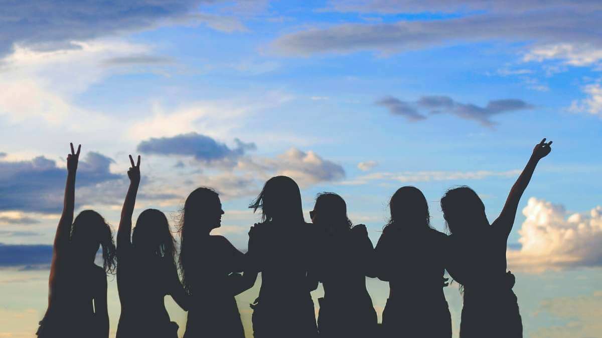 A group of hally sex workers, erotic massage workers, and escorts, silhouetted against a blue sky.