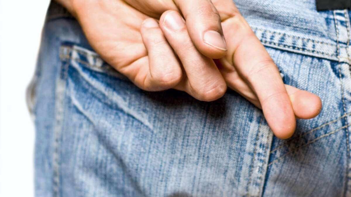 An escort client crosses his fingers behind his back.