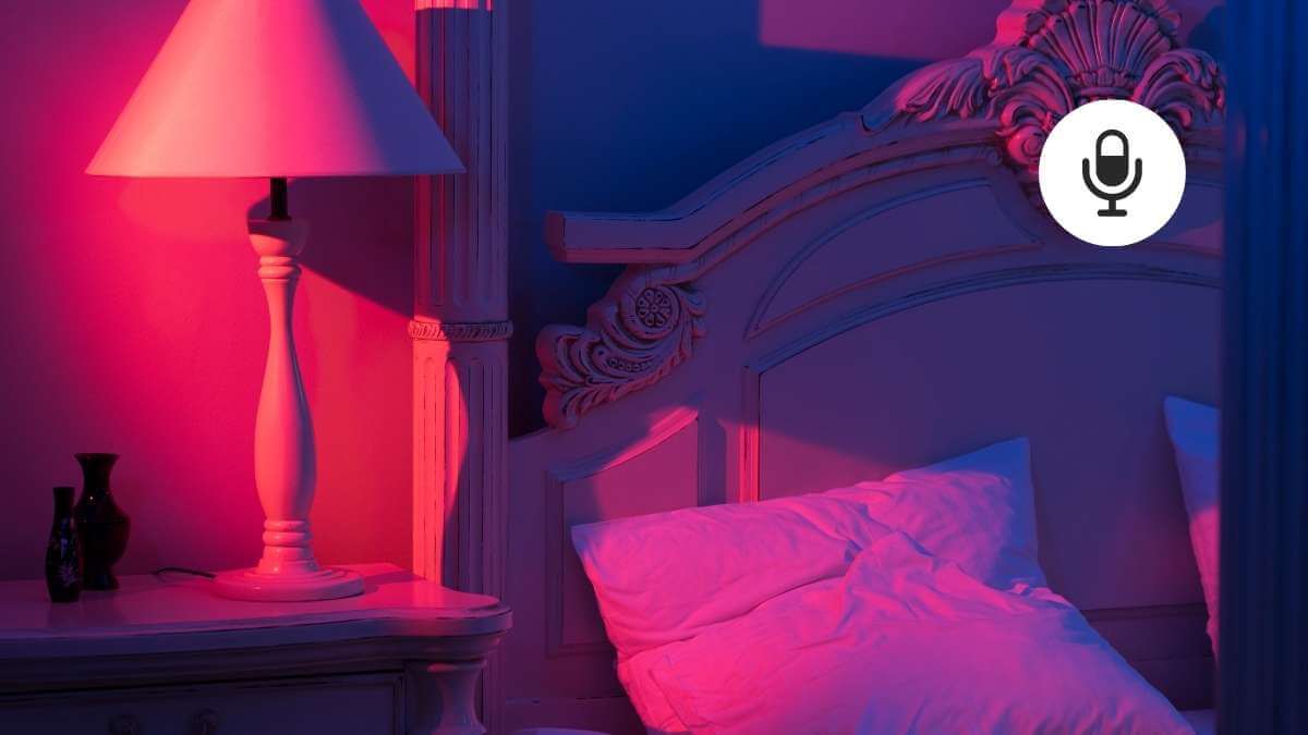A female escort's incall or brothel room, wth a pink bedside lamp.