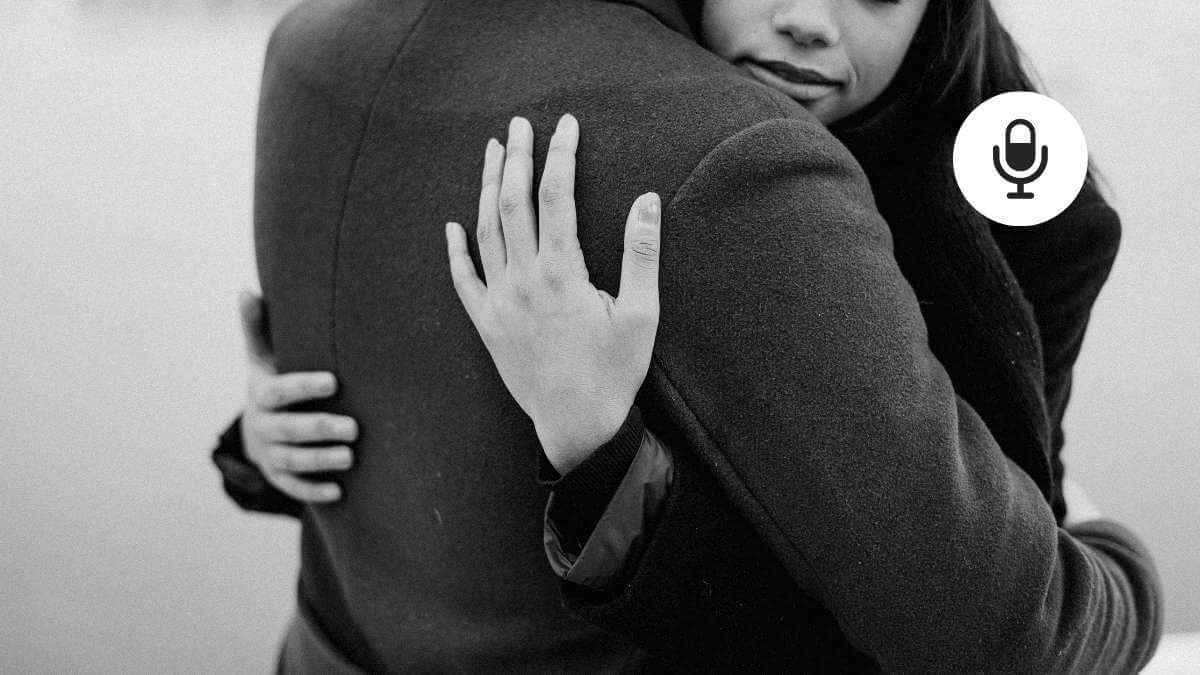 A female sex work client and her male escort hugging, while wearing winter coats.