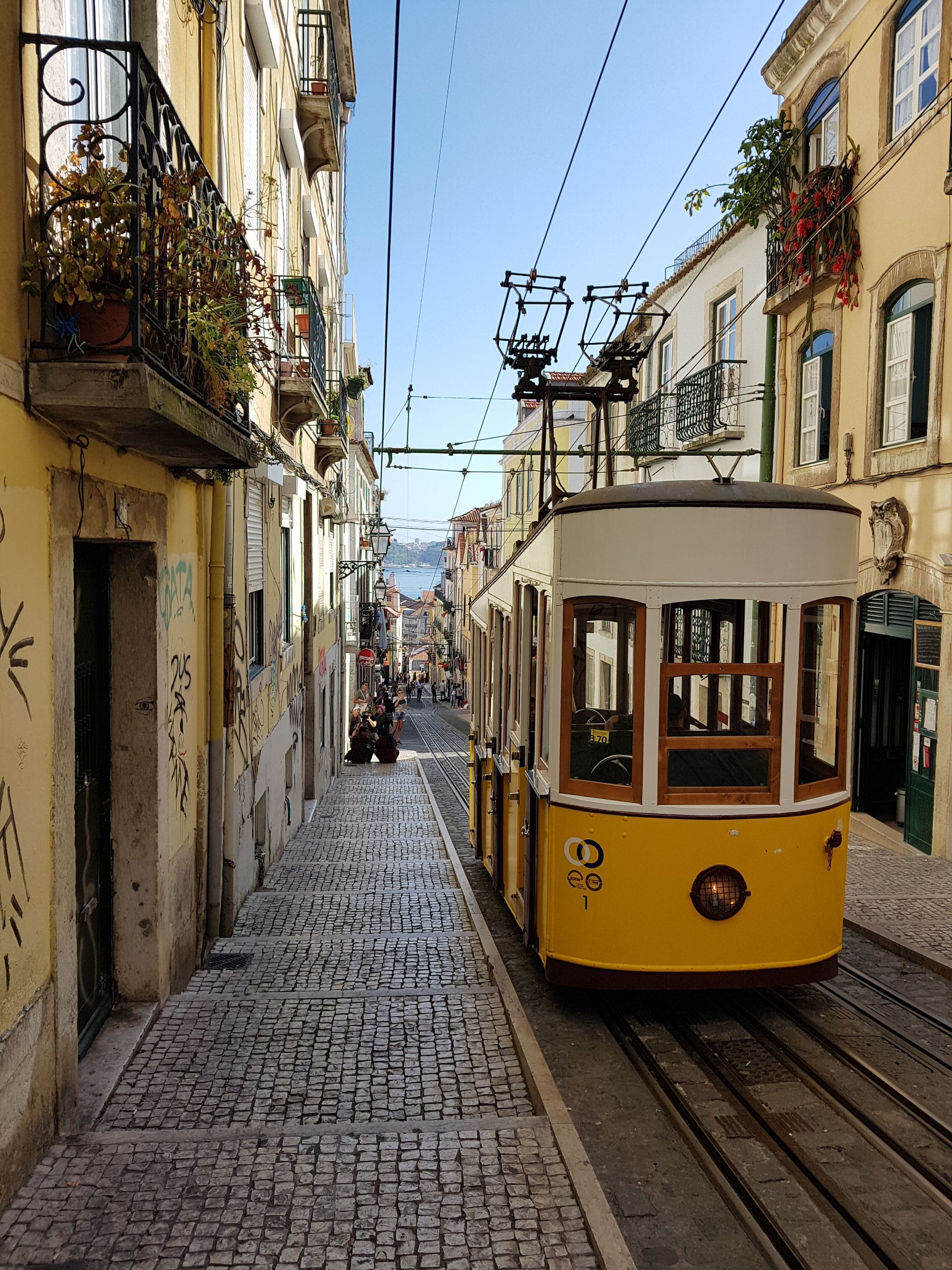 Photo d’un tramway jaune et blanc dans les rues de Lisbonne (Portugal).