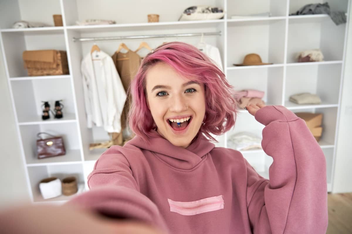 brand awareness - woman influencer with pink hair filming in front of closet