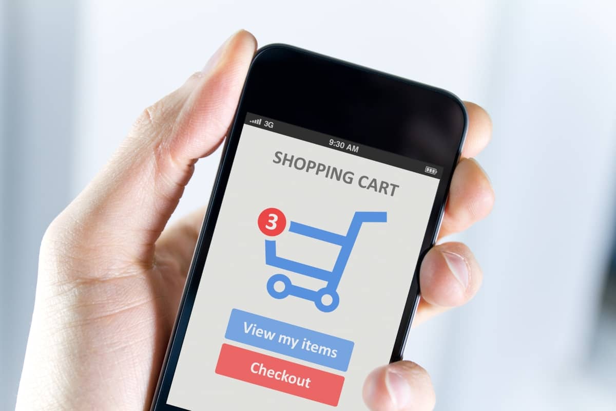 ecommerce email marketing - man's hand holding smartphone with a mobile cart app