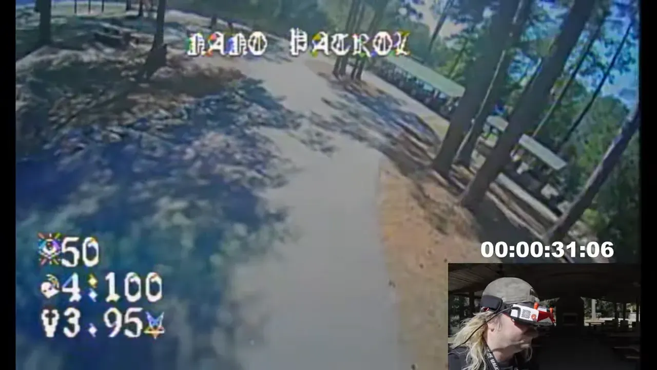 Analog drone flying smoothly over park grass, captured from FPV goggles