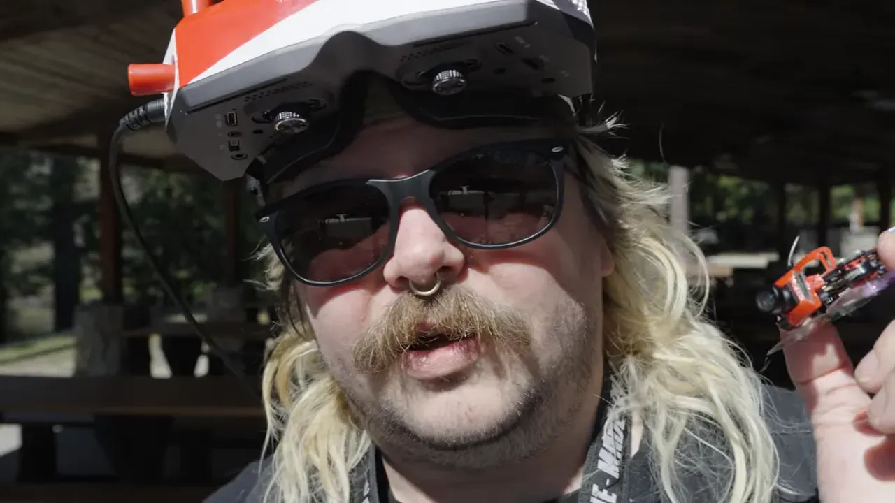 Host promoting Patreon and Discord while holding the tiny drone