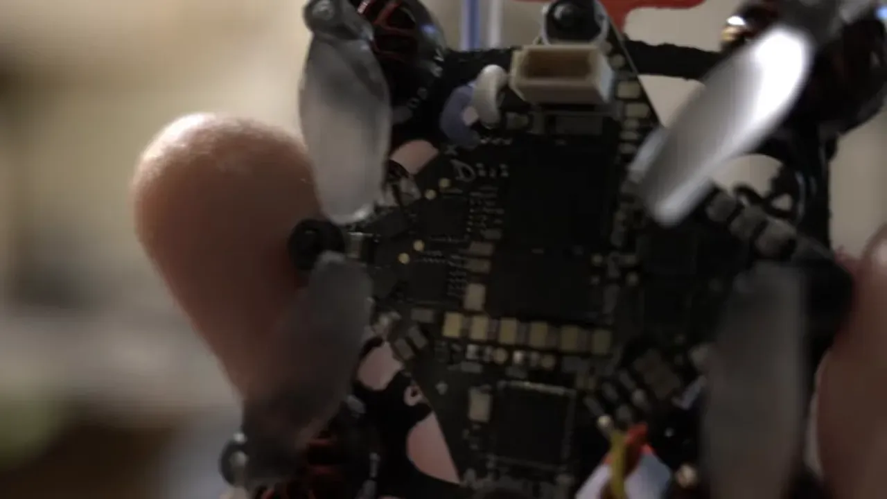 Close-up shot of the tiny drone frame, described as a 'flying microchip'