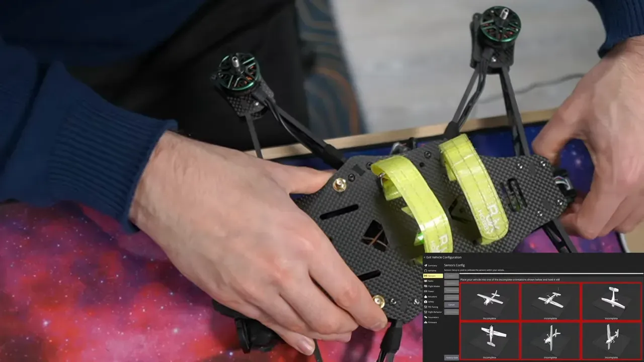 Top-down view of a quadcopter frame held on a workbench, ready for sensor calibration, with a QGroundControl sensors-calibration inset