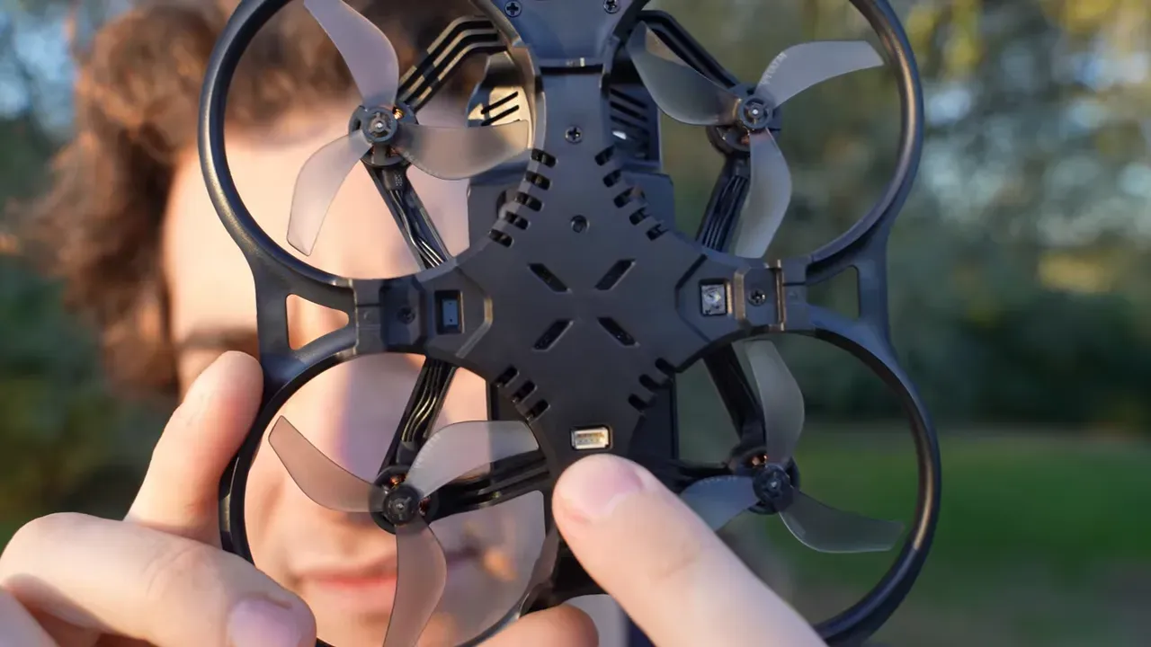 Front-on view of Aquila20 underside with bottom optical sensor and three‑blade propellers visible