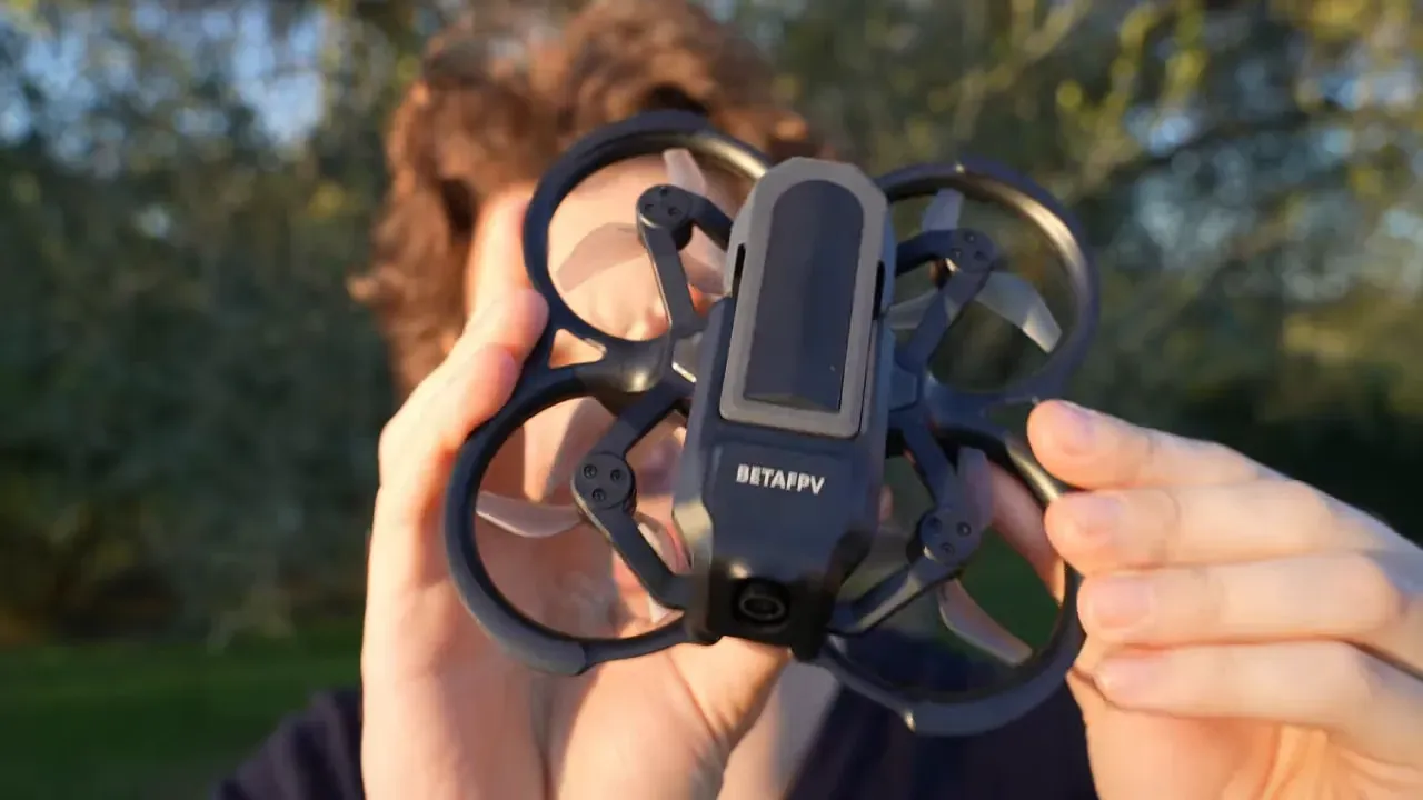 Front view of BetaFPV Aquila20 ducted whoop held up close showing prop guards, 2.2-inch props and front camera