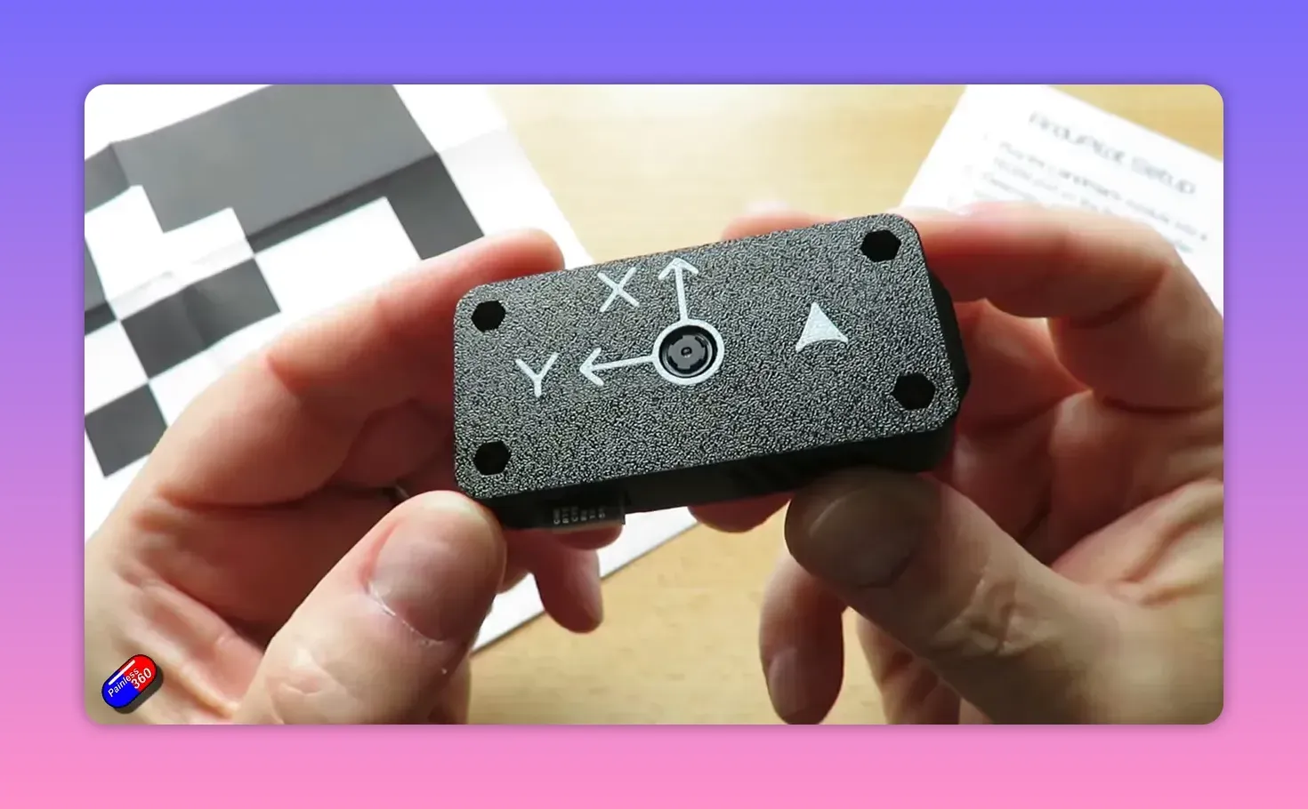 Landmark precision-landing unit held in hands showing camera aperture, X/Y orientation arrows and mounting holes