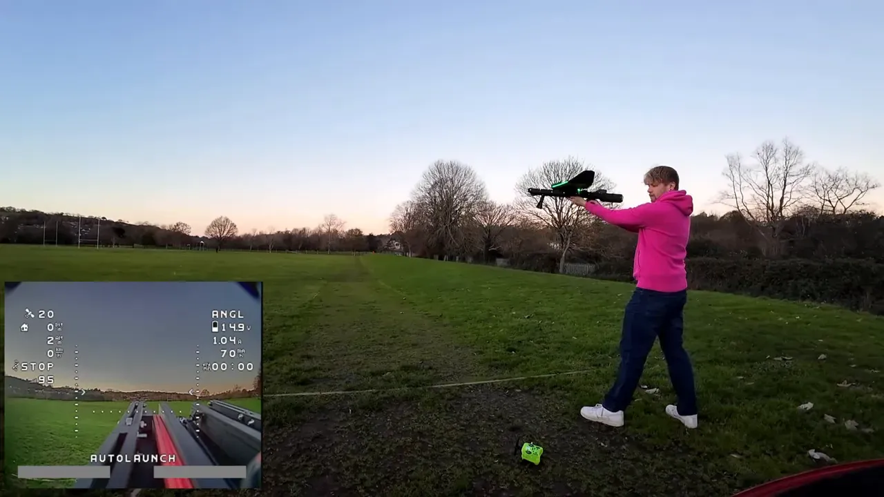 Pilot extending the Atom RC wing in the launch moment; green LEDs visible on the airframe