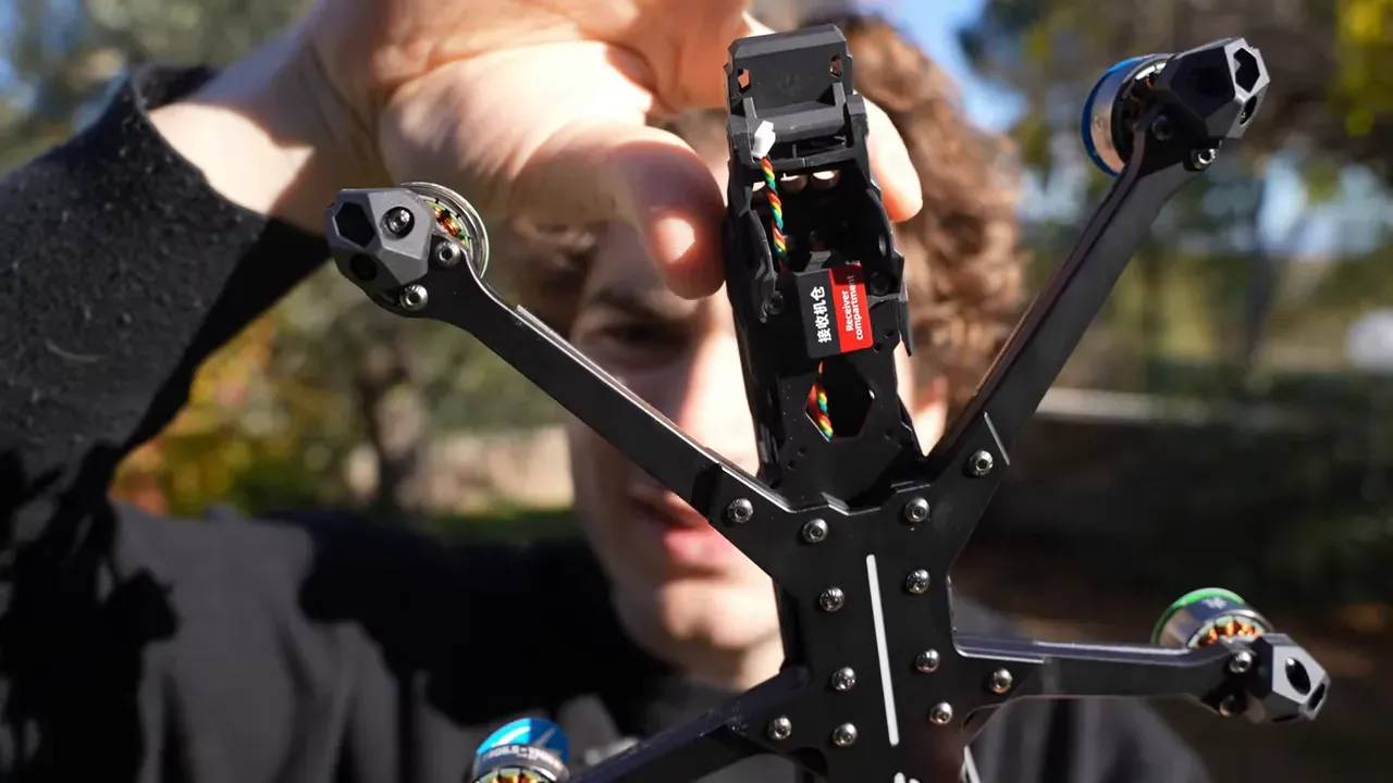 Open canopy and receiver bay of HGLRC NBlade MAX showing internal wiring and a red receiver module