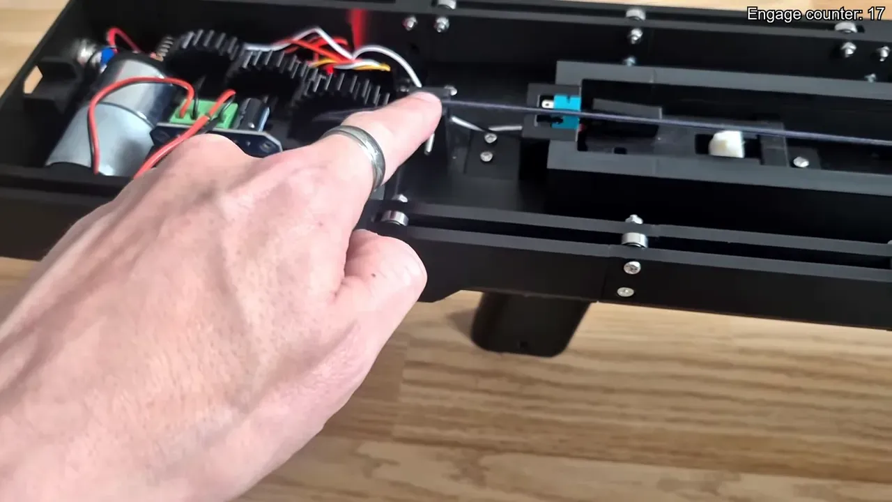 Close-up of Drone Slinger V2 geartrain, shuttle and operator finger indicating the bearing/shim area