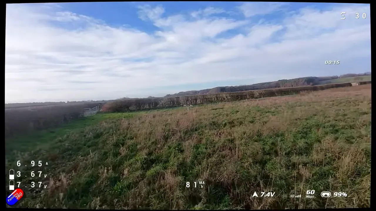 FPV flight view over grass with clear telemetry overlay showing mAh and voltage
