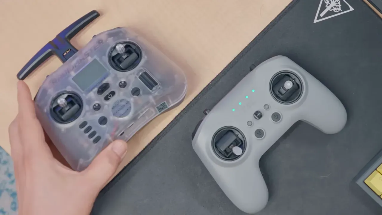 Top-down comparison of two handheld RC controllers placed side-by-side on a desk, showing gimbals and button layout