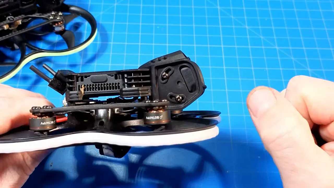 Profile shot of Pavo20 Pro II camera hood and mount with hand for scale on blue work mat