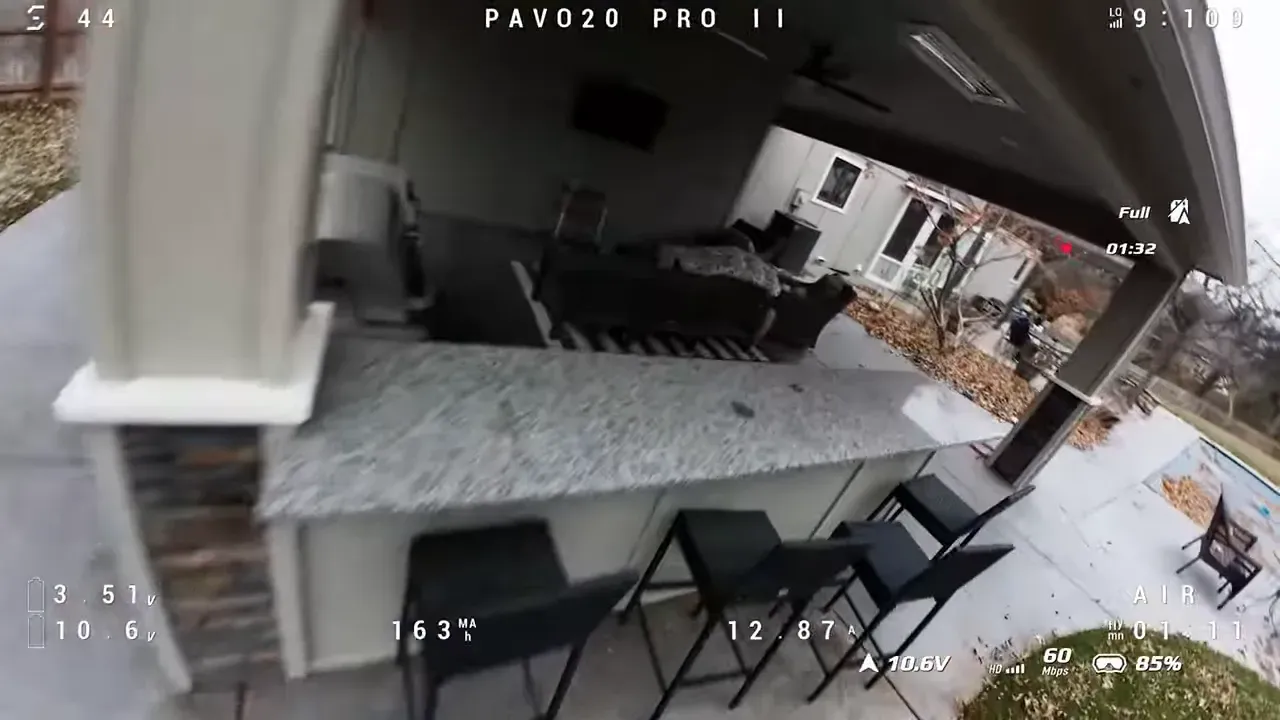 FPV close pass under a patio bar and overhang with stools and seating visible, telemetry overlay showing stable flight