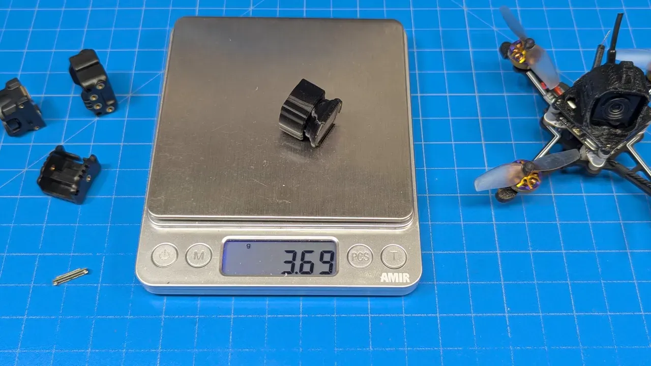 FlyWoo 3D-printed wide adapter sitting on a digital scale reading 3.69 g with drone and other parts visible on a blue work mat