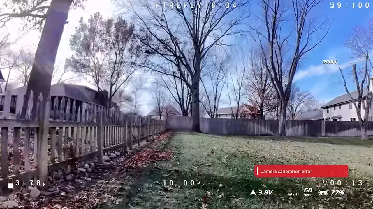 Wider DVR frame of a backyard with a fence, large tree and clear sky, with a red 'Camera calibration error' overlay