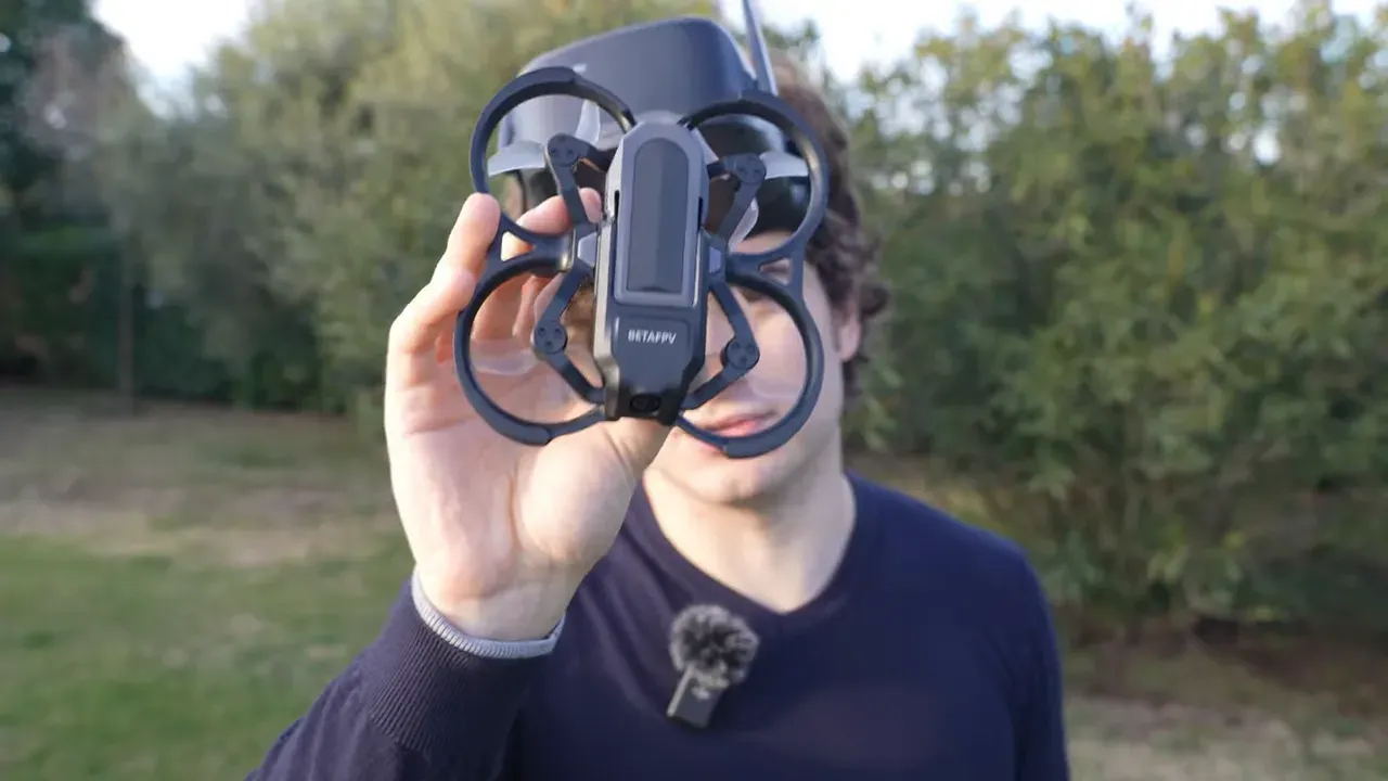 BetaFPV Aquila20 HD micro quad held up to camera showing ducted prop guards and front camera