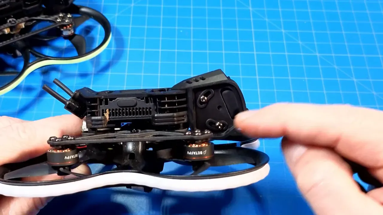 Close side view of a Pavo20 Pro II with the reviewer pointing at the camera hood to show clearance and protection