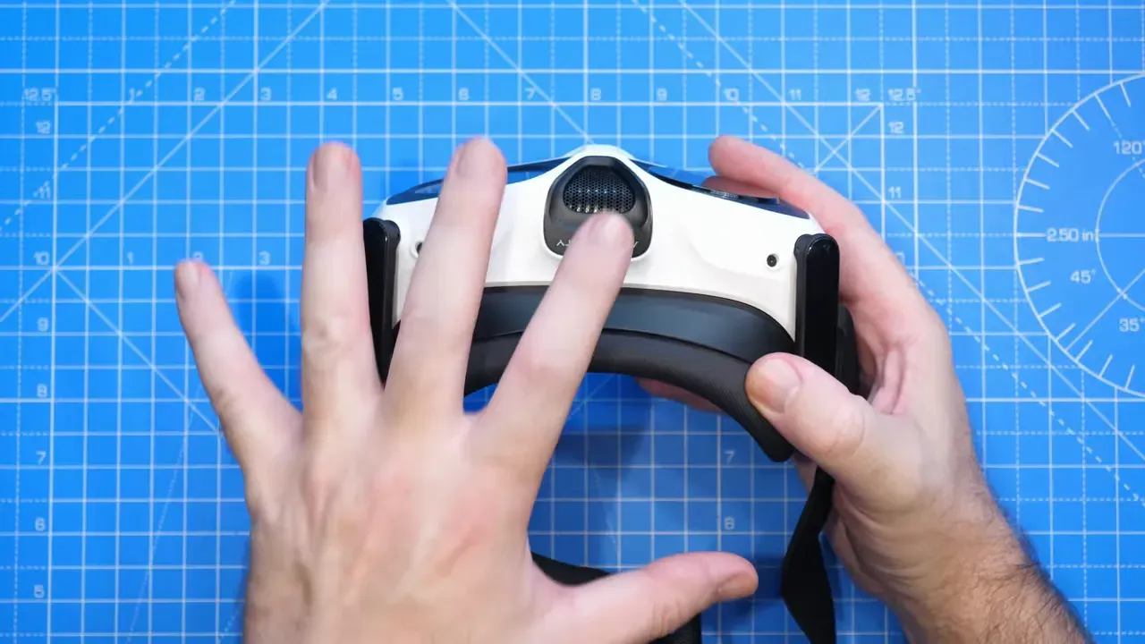 Top-down shot of Antigravity A1 Vision goggles held by reviewer over a blue grid cutting mat