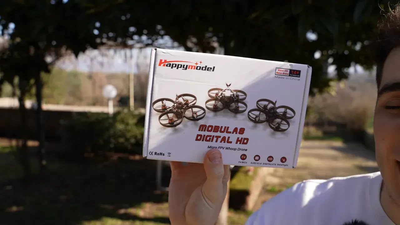 Clear front view of the Mobula 8 retail box held up to camera showing product name and images of the quad