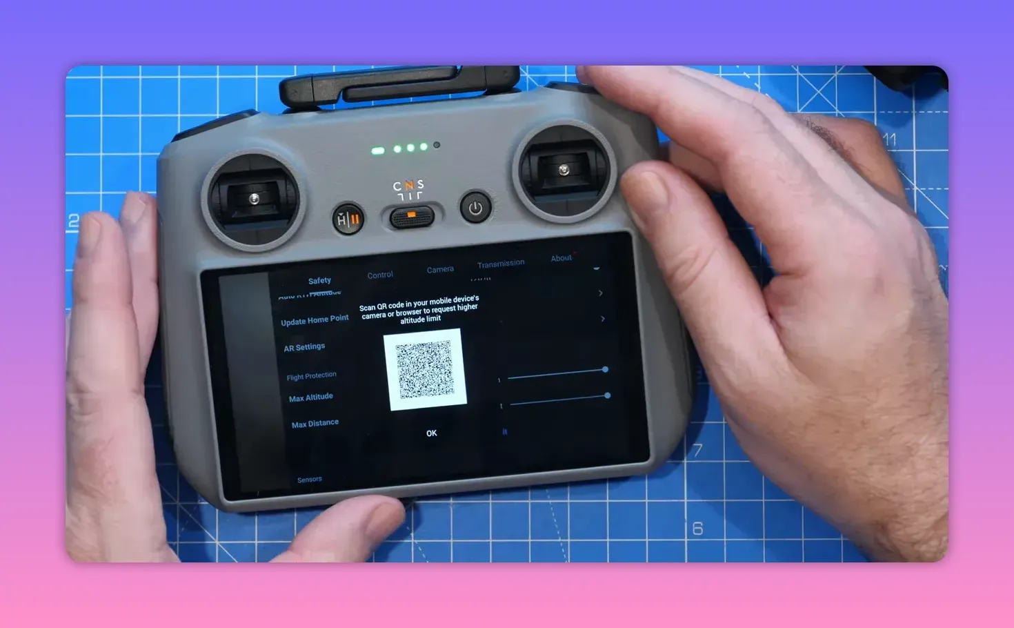 DJI controller screen showing the Fly app Safety tab with a QR code popup for requesting a higher altitude limit, hands visible on the controller
