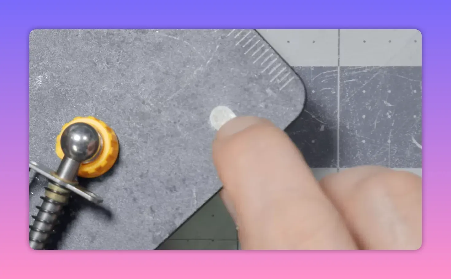 Finger pointing at a small circular contact on a magnetic helping‑hands base next to two ball‑joint posts, on a cutting mat