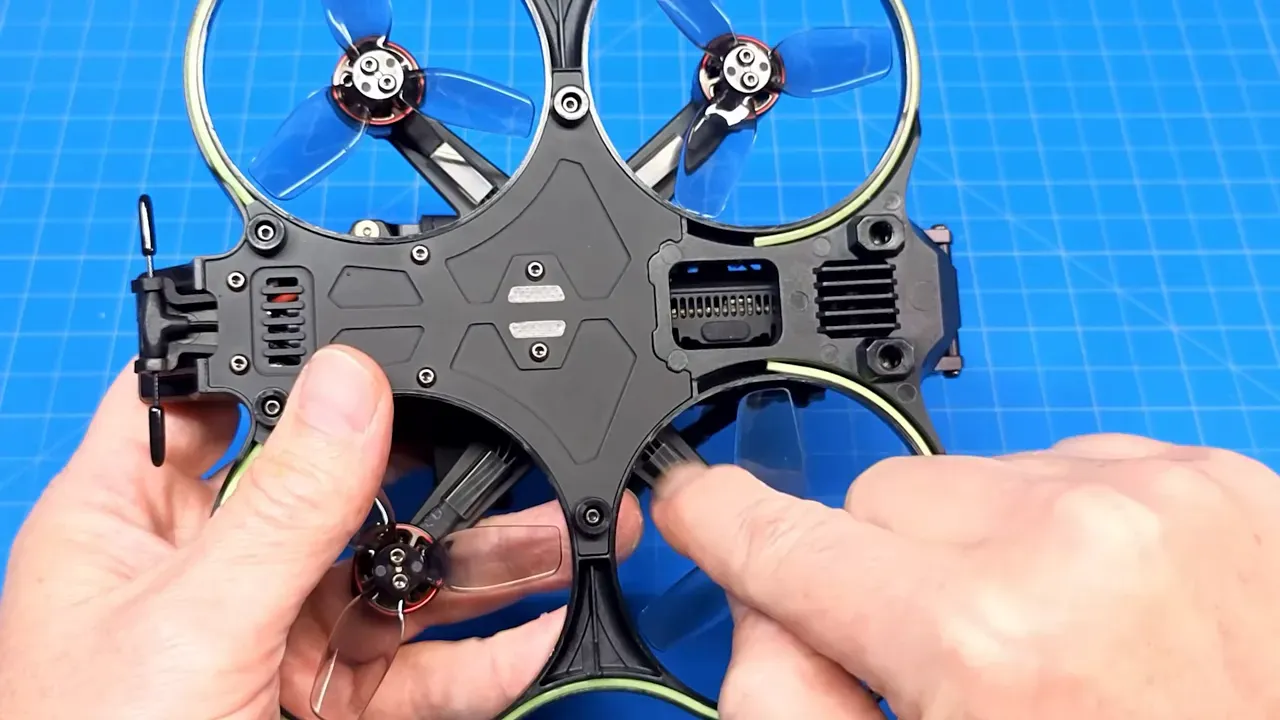 Cinebot25 V2 underside with hand indicating motor wire sheath close to the prop arc