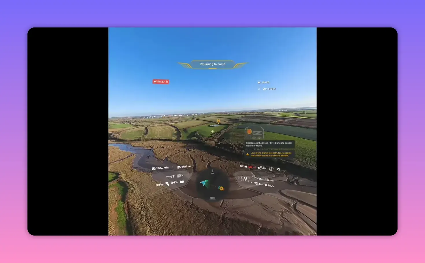 Clear FPV HUD over farmland with 'low drone signal strength' warning and return-to-home overlay