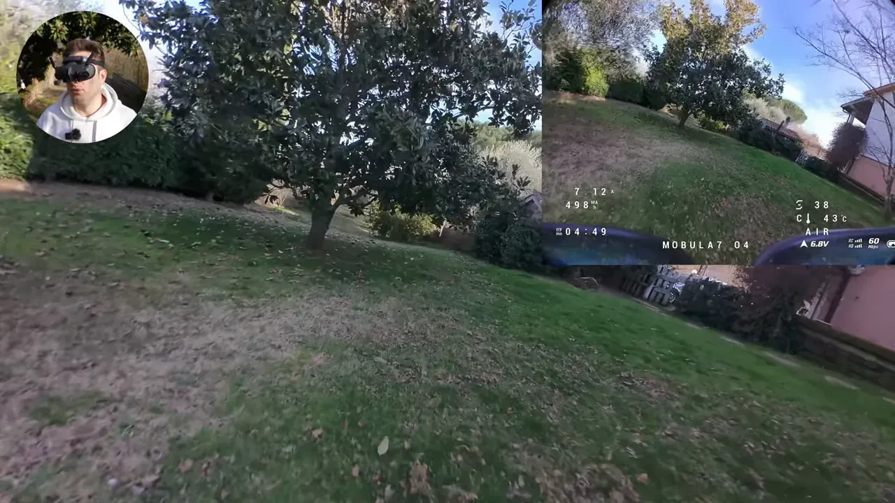 FPV view over a grassy yard and trees with presenter facecam inset and on-screen telemetry