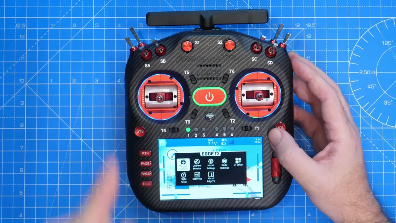 Top-down view of RadioMaster TX16S MK3 showing the 5-inch touchscreen with EdgeTX menu, front programmable buttons beneath the screen, gimbals with LED rings and hands operating the radio.