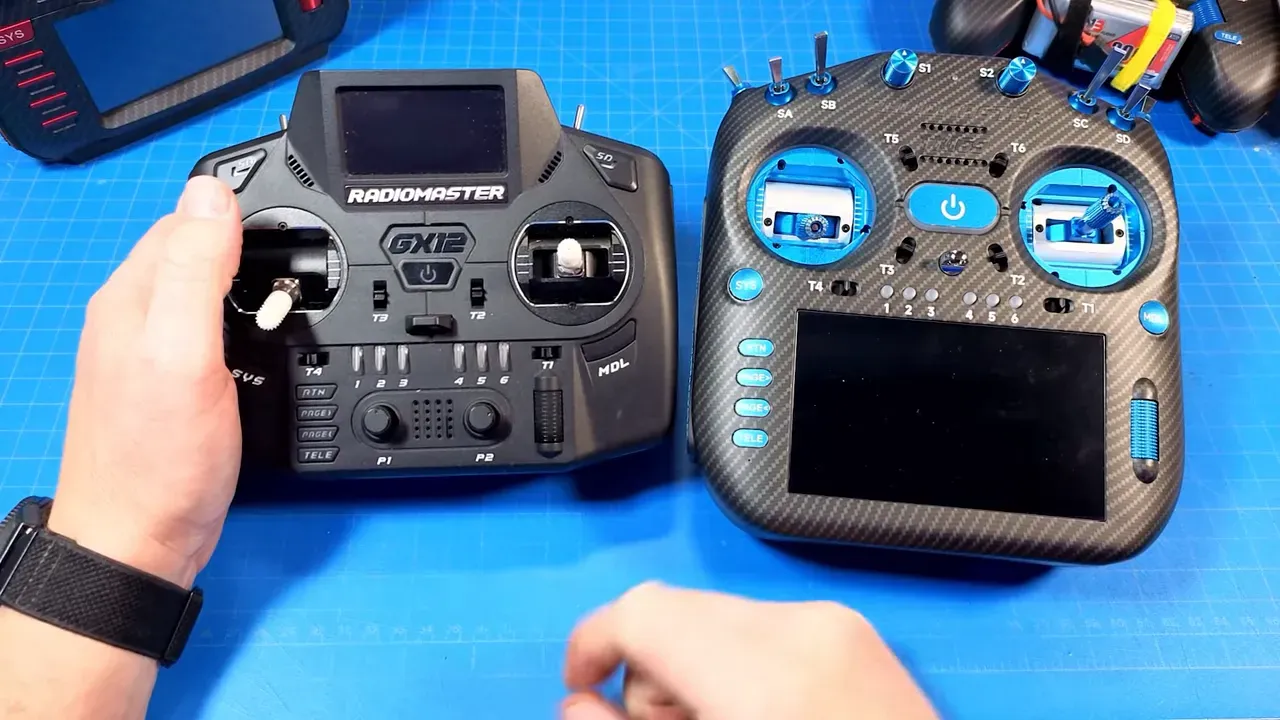 Side-by-side comparison: Radiomaster GX12 transmitter at left and TX16S Mk3 Max at right on a blue work mat, both controllers visible for scale