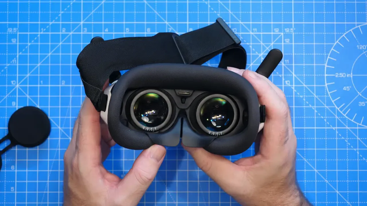 Inside view of Antigravity A1 Vision goggles showing pancake lenses, foam seal and strap on a blue work mat