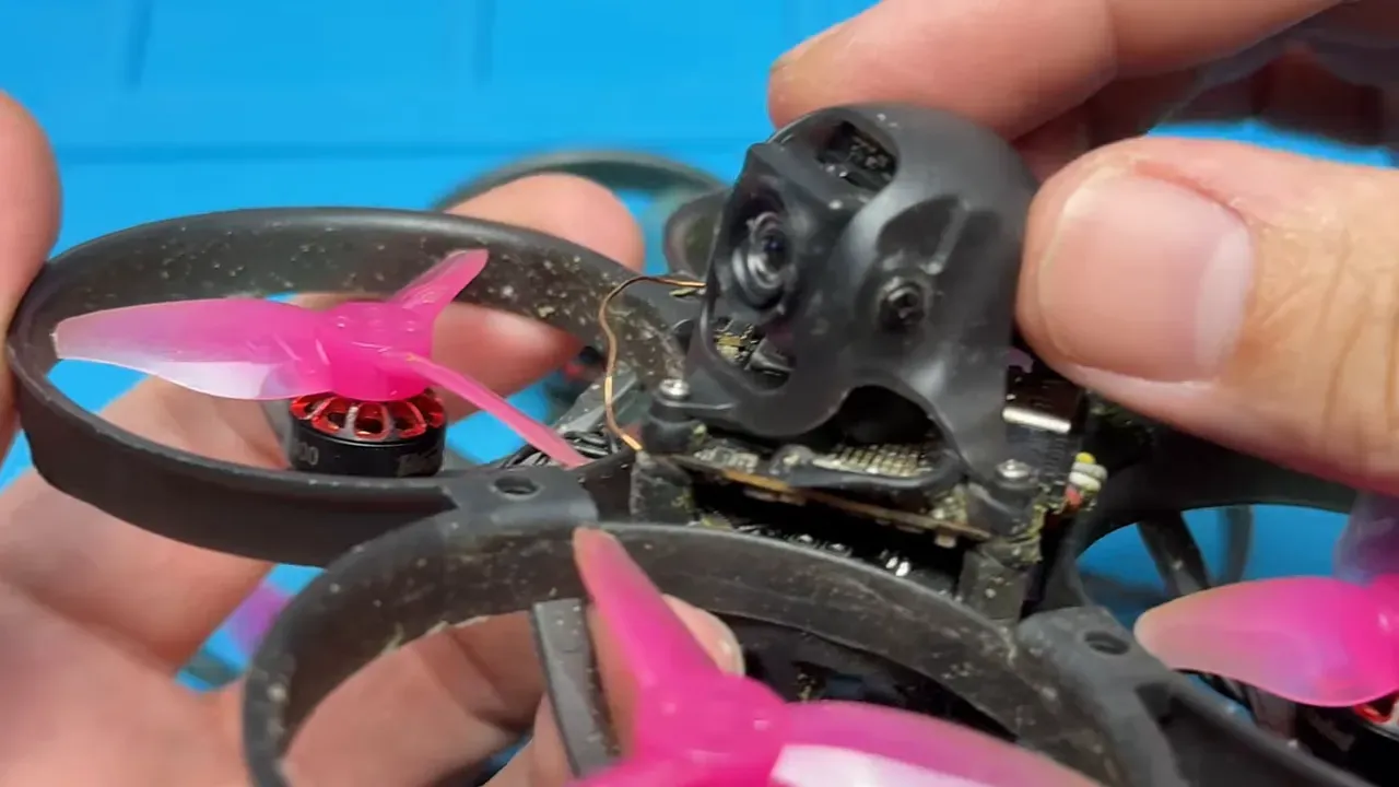 Close-up of a Mobula cinewhoop camera in its canopy with hands adjusting the canopy and extender lens