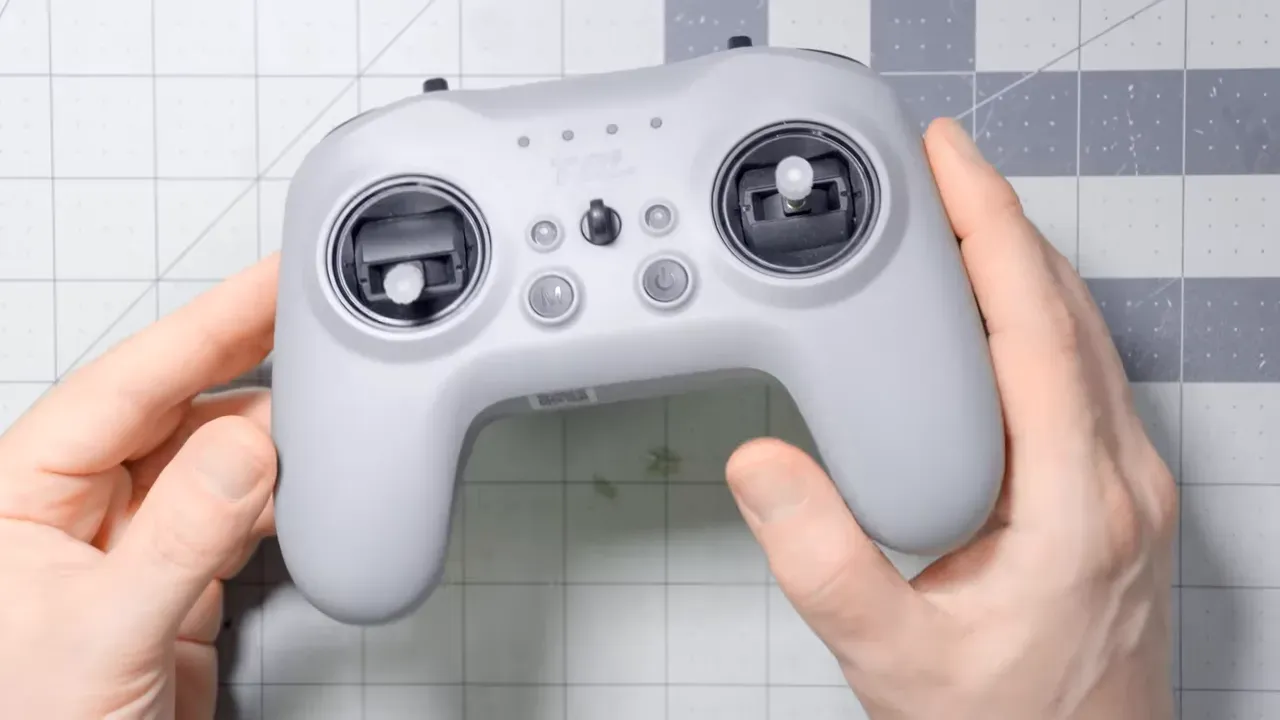 top view of a grey compact Radiomaster-style radio controller with sticks and power button visible