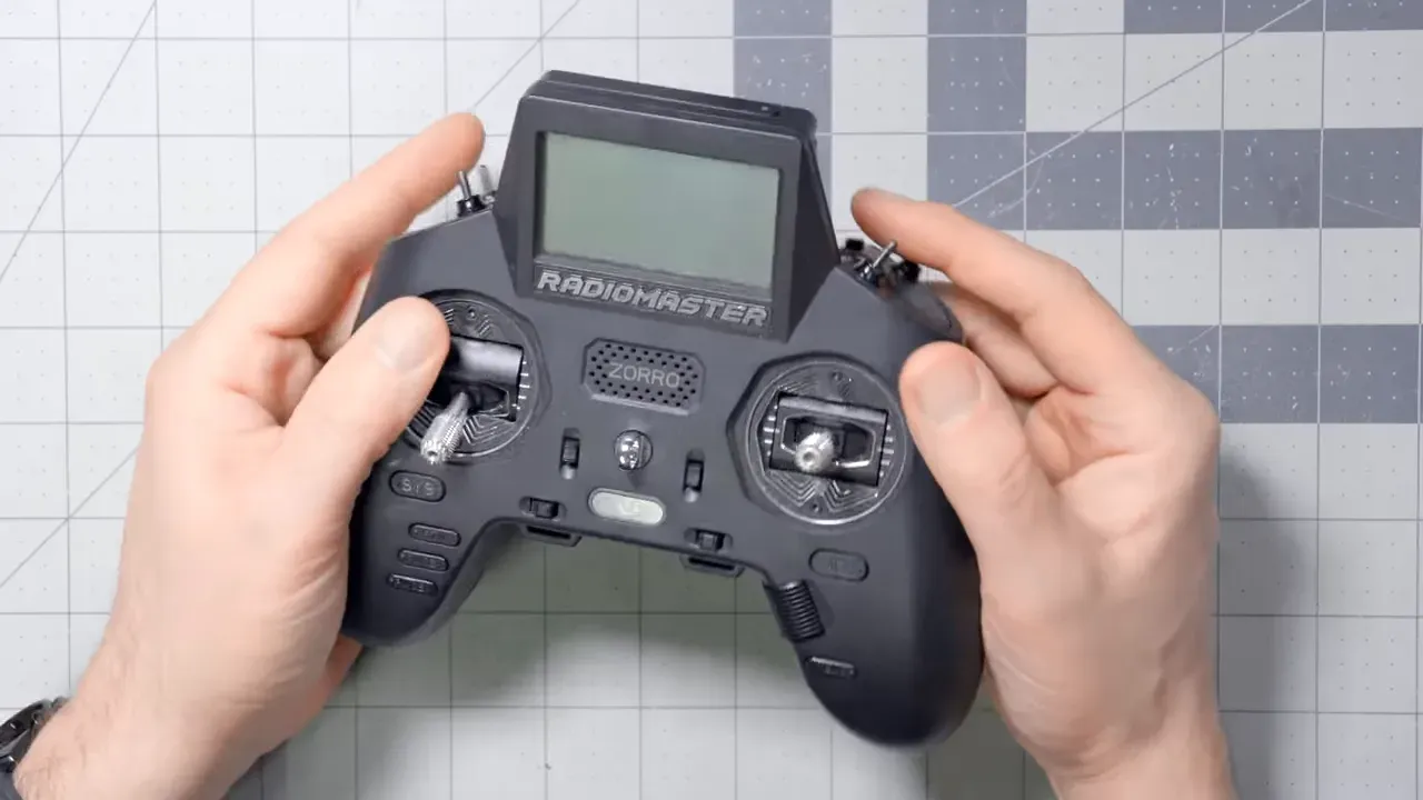 Top-down view of the Radiomaster Zoro gamepad-style radio held in hands showing both gimbals, small screen and buttons