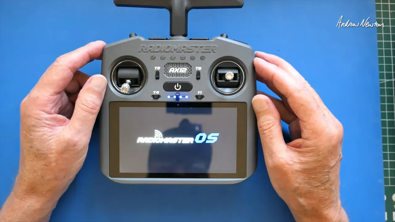Radiomaster AX12 held in hands with RadioMaster OS boot screen