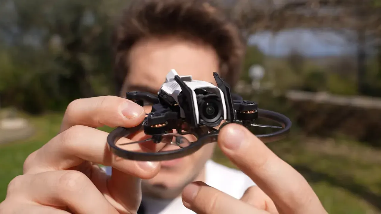 Oxbot Lumo18 tinywhoop front with 3D-printed camera protection horns in-hand outdoors