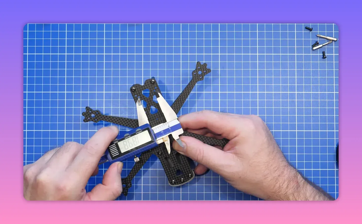 FpV ERA Mini rear frame area positioned on a blue cutting mat with hands in frame