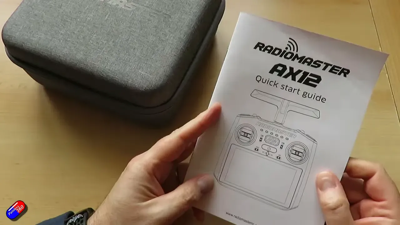 Radiomaster AX12 quick start guide held above the grey carrying case