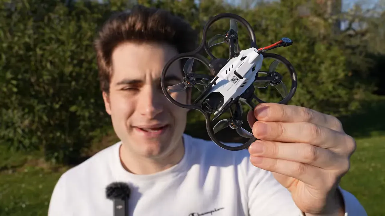 Reviewer holding the Oxbot Lumo18 tinywhoop outdoors with the DJI O4 Lite camera stack visible