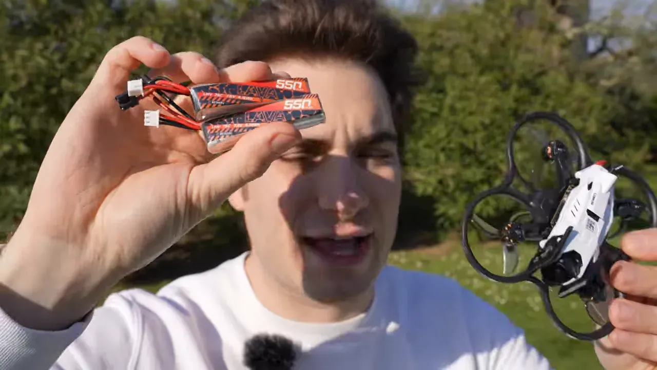 Hands holding 2S HV battery packs and the Oxbot Lumo18 ready for outdoor flight