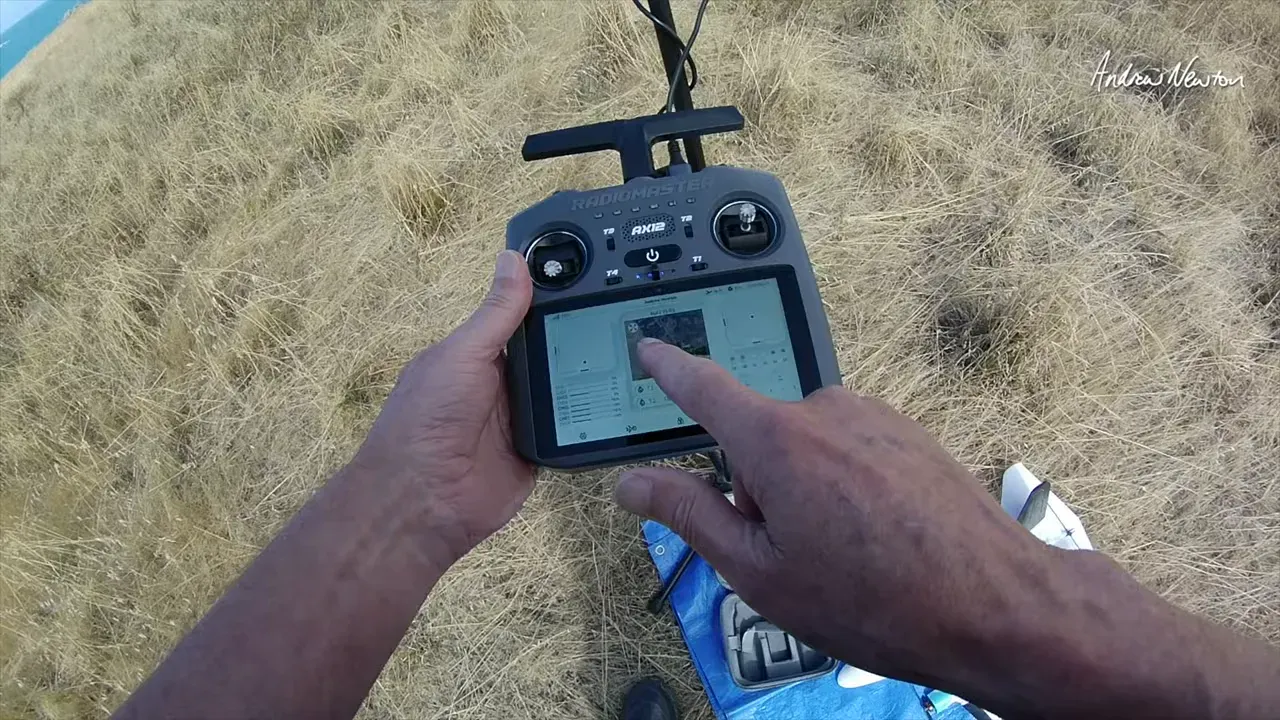 Radiomaster AX12 touchscreen in focus showing map or satellite interface while presenter taps