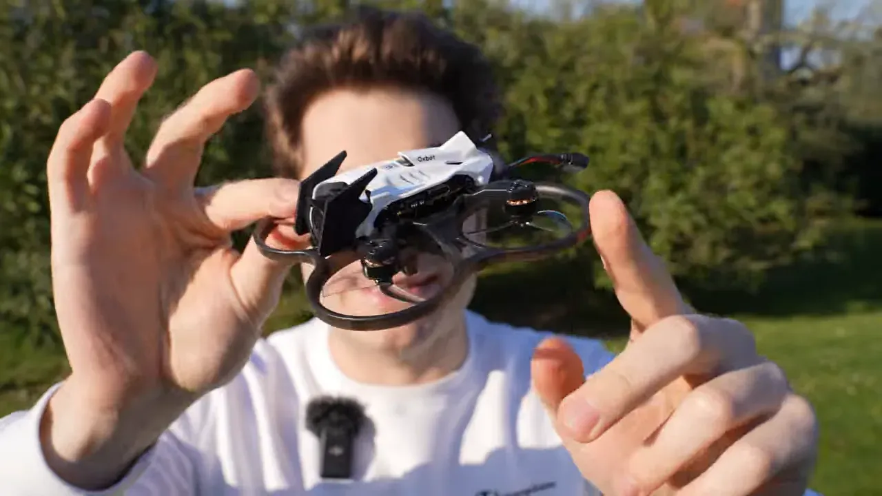 Person holding the Oxbot Lumo18 tinywhoop outdoors while reviewing the final verdict